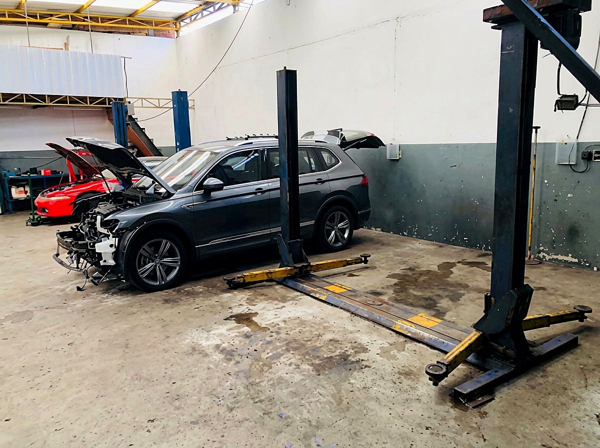 Veículo em manutenção ao lado do elevador automotivo