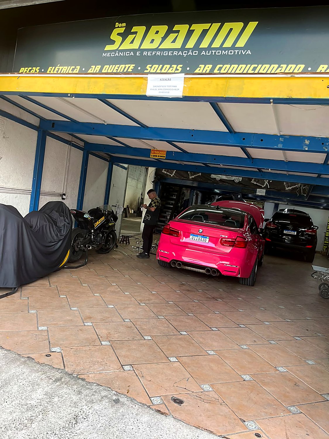 Entrada da oficina Dom Sabatini com veículos e motos em atendimento